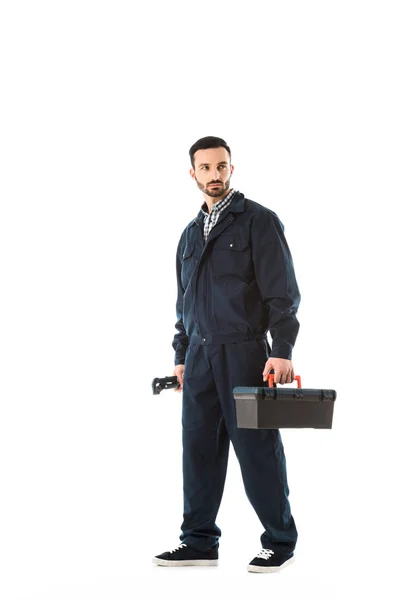 Serious Plumber Holding Adjustable Wrench Toolbox While Looking Back Isolated — Stock Photo, Image