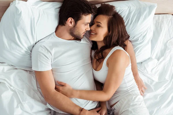 yatakta yatarken çekici kadın bakarak neşeli adam üst görünümü 