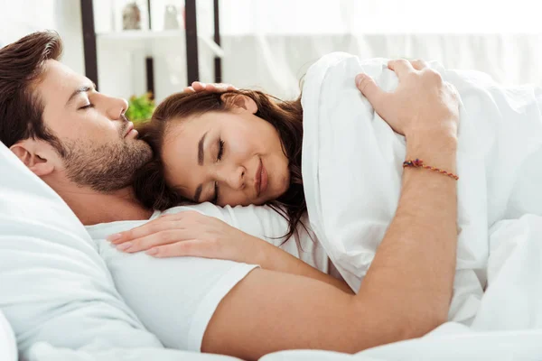 ベッドのハンサムな男の近くに毛布の下に横たわっている美しい女性 — ストック写真