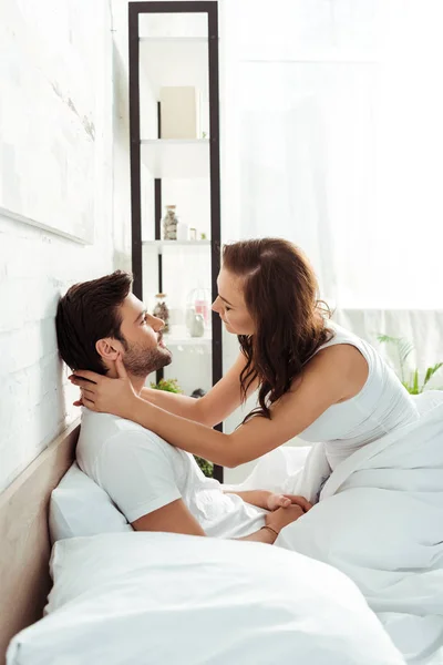 Yatakta Oturan Yatak Odasında Yakışıklı Adam Dokunmadan Mutlu Genç Kadın — Stok fotoğraf