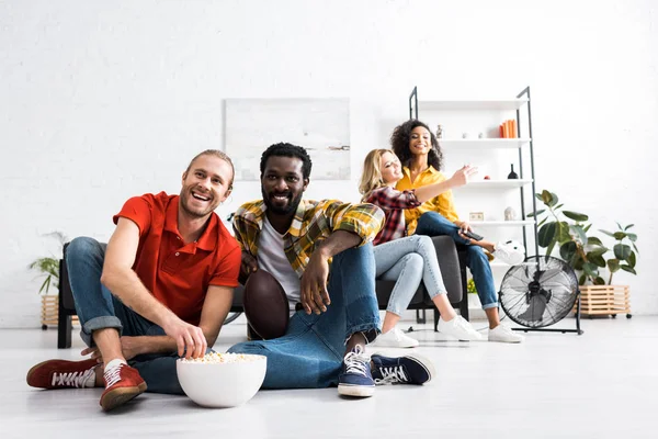 Dois Homens Multiculturais Assistindo Fósforos Comendo Pipocas Enquanto Duas Mulheres — Fotografia de Stock