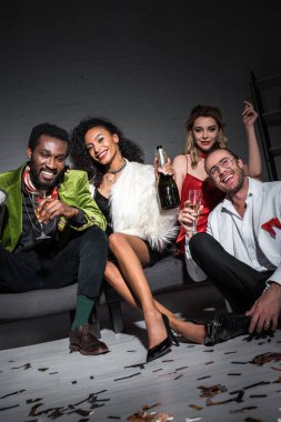 çok kültürlü arkadaşlar yanında otururken şişe tutan afrikalı amerikalı kız düşük açı görünümü