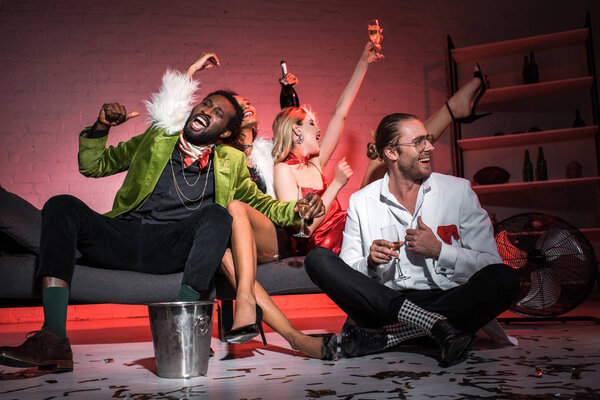 low angle view of happy multicultural friends celebrating in night club 