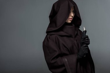 Ölüm kostümü giymiş bir kadın, elinde yanan bir mum tutuyordu.