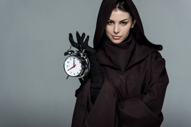 woman in death costume holding alarm clock isolated on grey clipart
