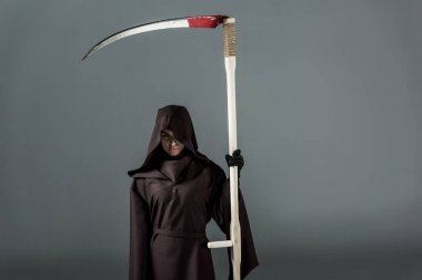 woman in death costume holding scythe on grey clipart