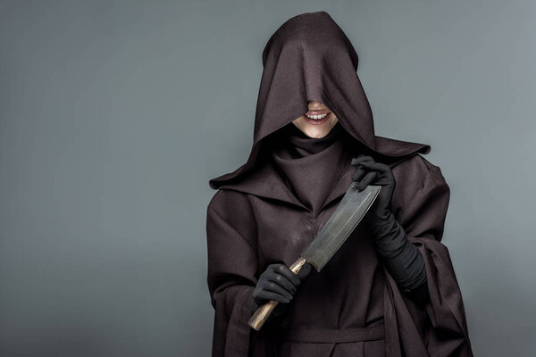 smiling woman in death costume holding cleaver isolated on grey