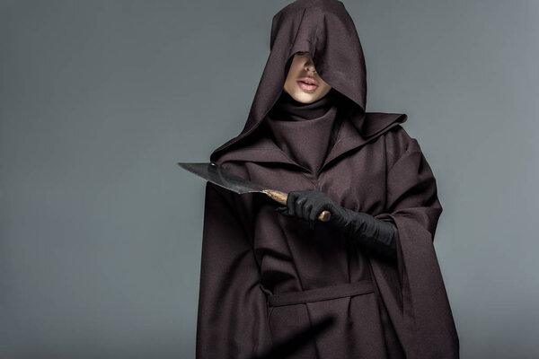 woman in death costume holding cleaver isolated on grey