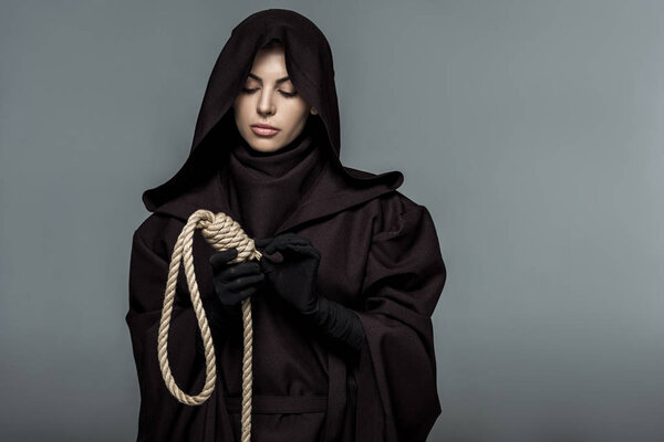 woman in death costume holding hanging noose isolated on grey