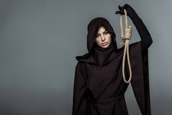 woman in death costume holding hanging noose isolated on grey