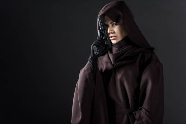 Ölü kostümlü kadın elinde silah tutuyor.