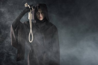 siyah üzerinde duman ilmik asılı tutan ölüm kostümü kadının ön görünümü
