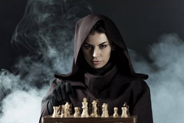 woman in death costume playing chess in smoke on black clipart