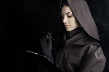 Ölü kostümlü kadın elinde siyah bir pano tutuyor.