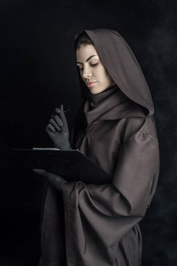 Ölü kostümlü kadın elinde siyah bir pano tutuyor.