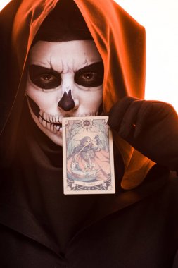 Kiev, Ukrayna - 18 Nisan 2019: kafatası makyajı tutan tarot kartı beyaz izole kadın