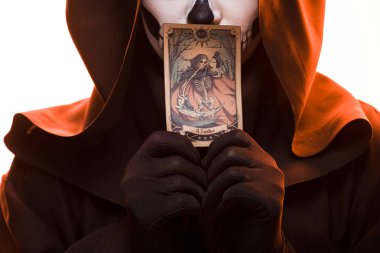 KYIV, UKRAINE - APRIL 18, 2019: cropped view of woman with skull makeup holding tarot card isolated on white clipart