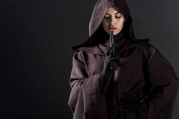 woman in death costume holding gun isolated on black