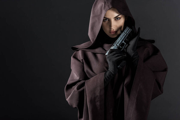 woman in death costume holding gun isolated on black