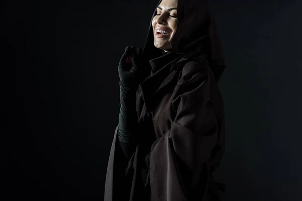 黒で隔離されたサイコロを持つ死の衣装で笑う女性 — ストック写真