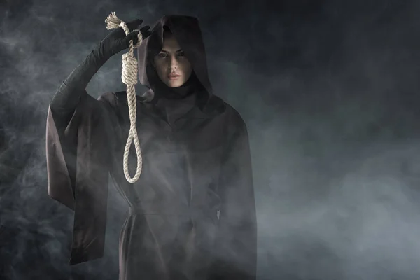 黒い煙の中で首を吊る死の衣装を着た女性の正面図 — ストック写真