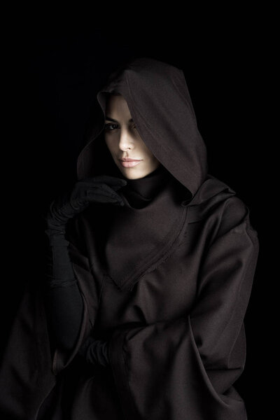 pensive woman in death costume looking at camera isolated on black