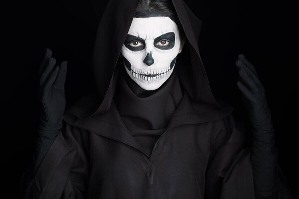 woman with skull makeup looking at camera isolated on black