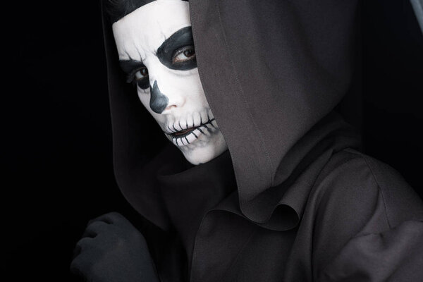 woman with skull makeup looking at camera isolated on black