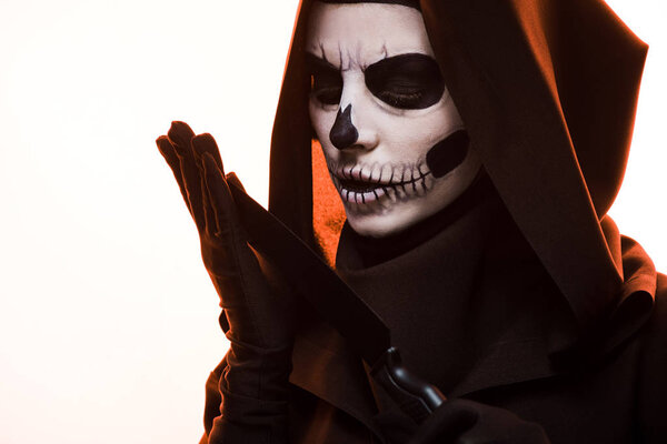 женщина с макияжем черепа держа нож изолирован на белом
