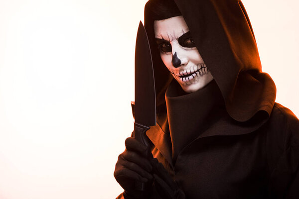 woman with skull makeup holding knife isolated on white