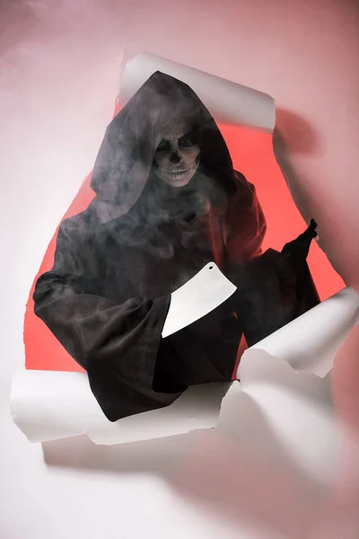 Kobieta Kostiumie Śmierci Trzymając Tasak Wychodząc Dziury Papierze — Zdjęcie stockowe