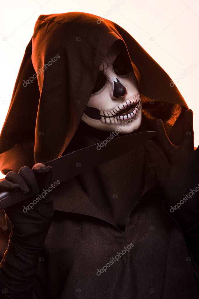 woman with skull makeup holding knife isolated on white