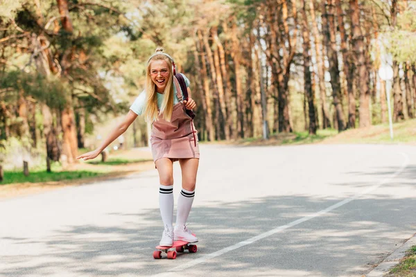 Plná Délka Pohled Vzrušená Blondýnka Skateboardingu Naslouchající Hudba Sluchátkách — Stock fotografie