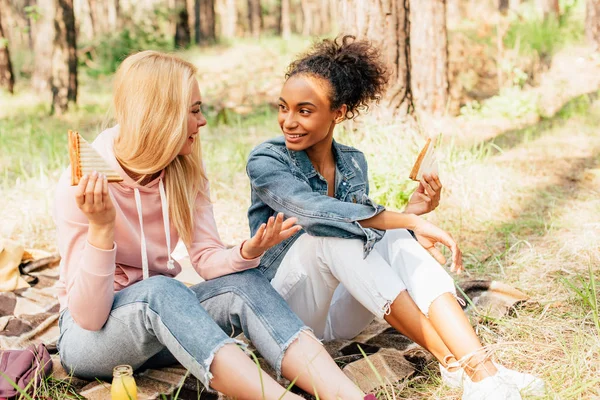 Two Smiling Multiethnic Friends Sitting Blanket Sandwiches Looking Each Other — Stock Photo, Image