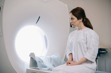 hastanede bilgisayarlı tomografi tarayıcı yatakta oturan çekici kadın