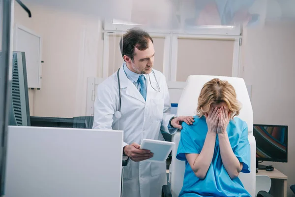 Селективное Внимание Врача Цифровым Планшетом Трогательным Плечом Плачущего Пациента &amp;mdash; стоковое фото