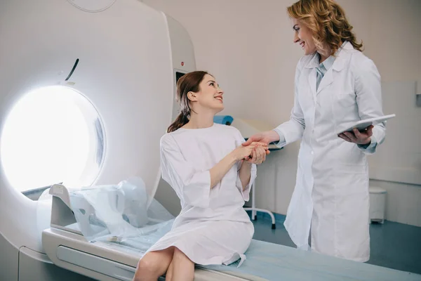 Uśmiechnięty Radiolog Trzyma Ręce Szczęśliwą Kobietą Siedzi Tomografii Komputerowej Skanera — Zdjęcie stockowe