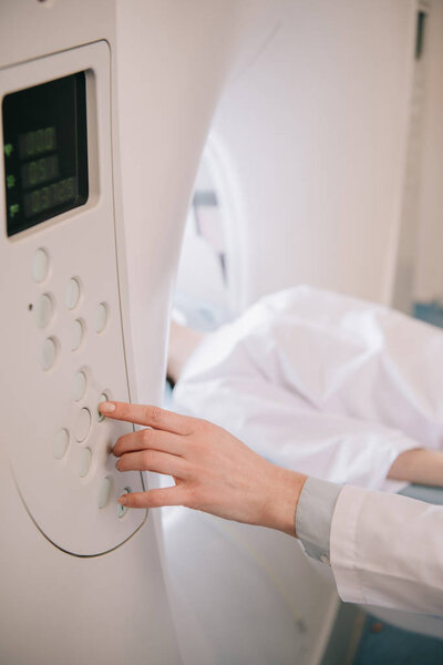 partial view of radiologist operating computed tomography scanner during patients diagnostics