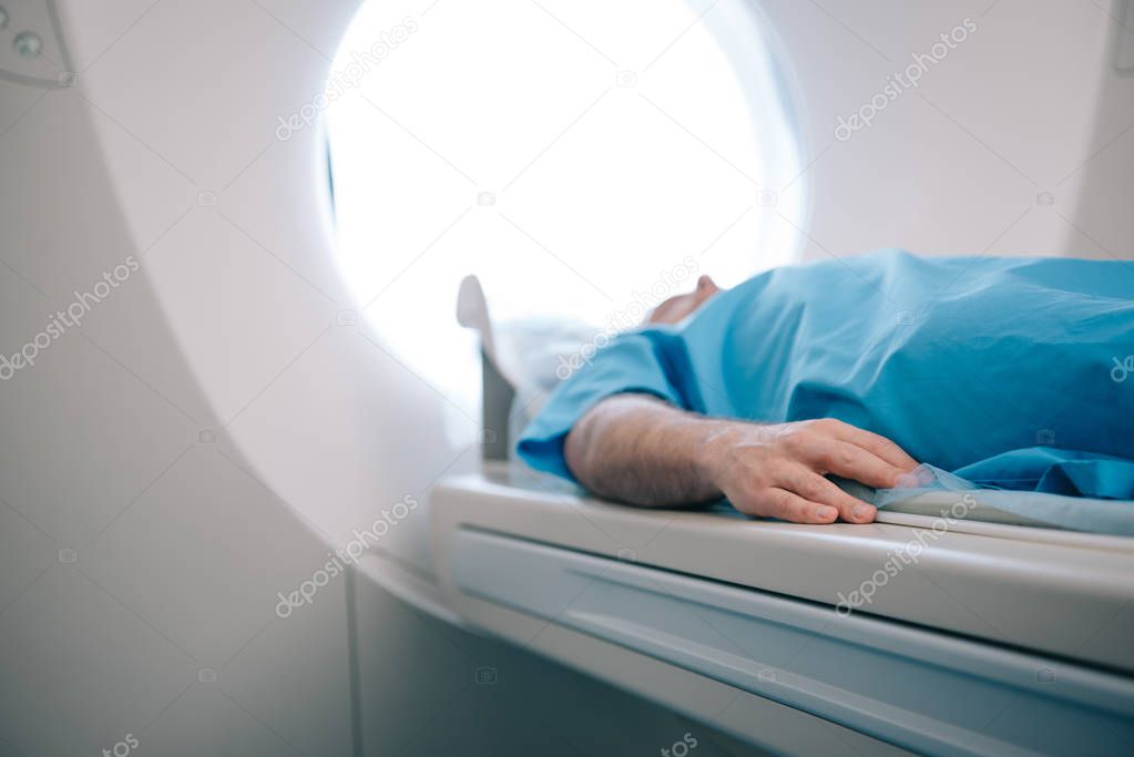 selective focus of patient lying on ct scanner bed during tomography test