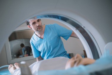 hasta tanıları sırasında bilgisayartomografi tarayıcısı çalıştıran özenli radyologun seçici odağı