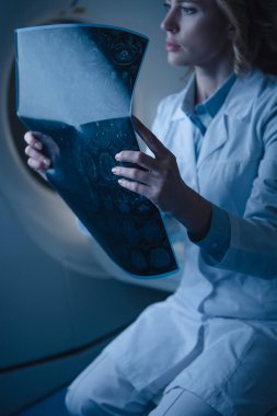 bilgisayarlı tomografi tarayıcı otururken x-ray tanısı tutan düşünceli doktor