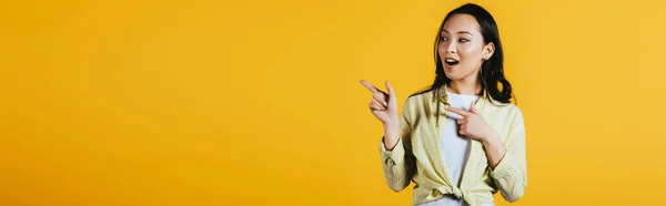 Happy Emotional Asian Girl Pointing Something Isolated Yellow — Stock Photo, Image