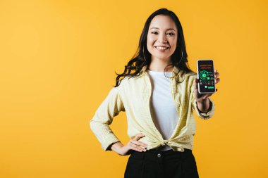 mutlu asyalı kız pazarlama analizi uygulaması ile akıllı telefon gösteren, sarı izole