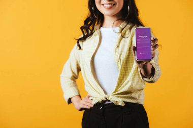 Kiev, Ukrayna - 16 Nisan 2019: sarışın izole instagram uygulaması ile akıllı telefon gösteren esmer kız kırpılmış görünümü