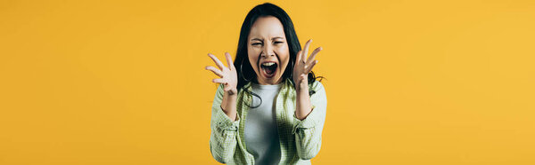 angry asian woman gesturing and yelling isolated on yellow