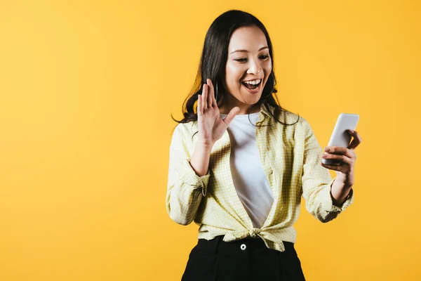 Щаслива Азіатська Дівчина Махає Робить Відео Дзвінок Смартфон Ізольовано Жовтому — стокове фото