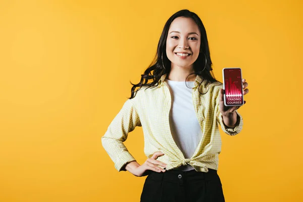 Happy Asian Girl Showing Smartphone Trading Courses Isolated Yellow — Stock Photo, Image