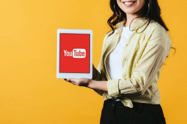 Kiev, Ukrayna - 16 Nisan 2019: youtube uygulaması ile dijital tablet gösteren gülümseyen kız kırpılmış görünümü, sarı izole