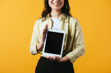 boş ekranlı dijital tablet gösteren kadının kırpılmış görünümü, sarı izole