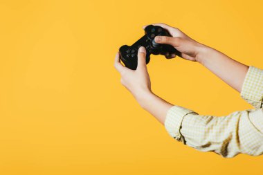 Kiev, Ukrayna - 16 Nisan 2019: joystick ile video oyunu oynayan kadın kırpılmış görünümü, sarı izole 